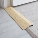 Beer Oak wood effect threshold ramp fitted in a doorway bridging laminate and vinyl flooring