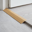 Beech wood effect threshold ramp fitted in a doorway bridging laminate and vinyl flooring