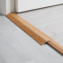 Cherry wood effect threshold ramp fitted in a doorway bridging laminate and vinyl flooring