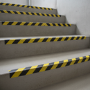 Black yellow hazard anti-slip tape on industrial stair nosings — HSE compliant step edge marking