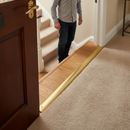 49mm wide aluminium door threshold strip in Gold — installed between floors at UK home doorway with person using it