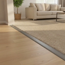 Grey PVC floor strip at living room entrance between wood flooring and carpet