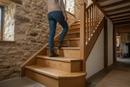 uPVC wood effect stair nosing in Country Oak — real-life installation on UK staircase with person using the stairs