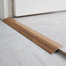 Afrezy wood effect threshold ramp fitted in a doorway bridging laminate and vinyl flooring
