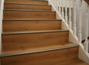Oak wood-effect laminate stair nosing matching walnut laminate staircase - looking down multiple steps, seamless finish