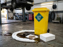 Yellow 120 litre oil and fuel spill kit bin in a vehicle maintenance workshop, white absorbent socks surrounding a diesel spill and white pads stacked alongside, van raised on a two-post lift and red tool chest behind