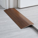 Indian Teak wood effect threshold ramp fitted in a doorway bridging laminate and vinyl flooring