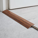 Togo Mahogany wood effect threshold ramp fitted in a doorway bridging laminate and vinyl flooring