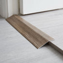 Antique Oak wood effect threshold ramp fitted in a doorway bridging laminate and vinyl flooring