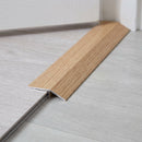 Elm wood effect threshold ramp fitted in a doorway bridging laminate and vinyl flooring