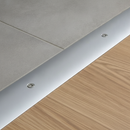 Close-up of 49mm aluminium door threshold strip installed between ceramic tile and laminate flooring - screw fix