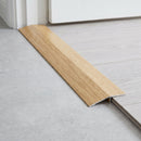 Light Oak wood effect threshold ramp fitted in a doorway bridging laminate and vinyl flooring