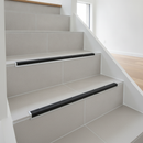 Heavy duty tile-in stair nosing installed on ceramic tiled staircase in modern UK home