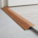 Mahogany wood effect threshold ramp fitted in a doorway bridging laminate and vinyl flooring