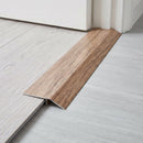 Merbau wood effect threshold ramp fitted in a doorway bridging laminate and vinyl flooring
