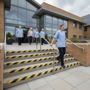 Black and yellow GRP stair nosing on concrete steps at UK NHS hospital entrance