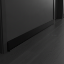Black flexible self-adhesive skirting board trim in modern UK hallway with dark flooring