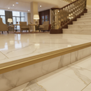 Matt Brass gold NAS aluminium stair nosing on marble-effect luxury staircase in high-end UK home