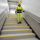 Heavy duty tile-in stair nosing in Yellow — real-life installation with person using tiled UK staircase