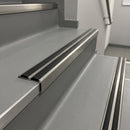 Inox anodised 36mm slim aluminium stair nosing with twin black rubber inserts on grey vinyl commercial stairwell steps