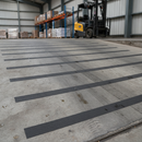 Black anti-slip tape strips applied across industrial loading ramp for traction
