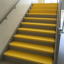 Yellow GRP full tread covers on UK school staircase — complete step surface coverage DDA compliant (5/5 accuracy)
