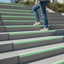 Photoluminescent anti-slip tape in normal daylight — pale green strip on staircase treads
