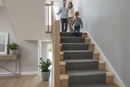 uPVC wood effect stair nosing in Natural Oak — real-life installation on UK staircase with person using the stairs