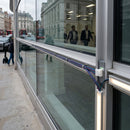 RGB LED lighting system installed in glass storefront railing with colorful extension cables visible