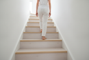 uPVC wood effect stair nosing in White Oak — real-life installation on UK staircase with person using the stairs