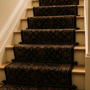 Black stair rods installed on carpeted staircase with dark patterned runner — elegant British hallway