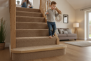 uPVC wood effect stair nosing in Verden Oak — real-life installation on UK staircase with person using the stairs