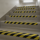 Black/yellow anti-slip stair treads on commercial concrete steps — DDA step edge marking