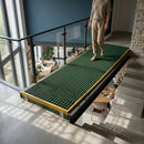 Person standing on green anti-slip GRP grating platform in modern multi-level interior space