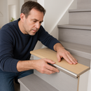 Homeowner installing push-in laminate stair nosing on UK grey laminate staircase - DIY installation method