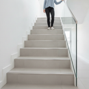 Tile-in aluminium step edging in Silver — installed on tiled UK staircase with person using the stairs