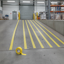 Yellow anti-slip tape strips on industrial loading ramp providing traction and hazard marking