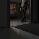 49mm wide aluminium door threshold strip in Black — installed between floors at UK home doorway with person using it