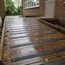 Black 50mm fine grit GRP anti-slip strips screwed across a school timber walkway and ramp