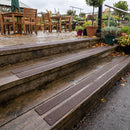 Brown 50mm fine grit GRP anti-slip strips on timber steps up to a garden centre cafe terrace