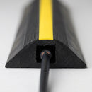 Cut cross section of the single channel rubber cable cover showing one enclosed square channel with a cable seated inside, yellow top strip and tapered side edges