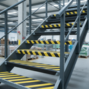 Black/yellow GRP heavy duty stair tread covers on industrial stairs — hazard marking and anti-slip