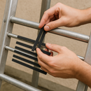 Person applying 19mm anti-slip strips to metal ladder rungs — peel and press installation