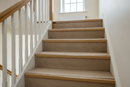 uPVC wood effect oak stair nosing installed on carpeted UK home staircase - edge protection and stair finish