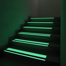 Photoluminescent anti-slip stair tread glowing on emergency exit stairs in low light