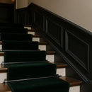Pewter stair rods securing deep green velvet runner carpet on period British staircase