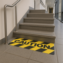 CAUTION anti-slip stair tread applied to office building steps with safety warning text