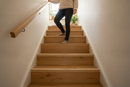 uPVC wood effect stair nosing in Rosario Spruce — real-life installation on UK staircase with person using the stairs