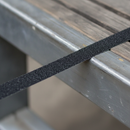 Close-up of 19mm anti-slip strip on ladder rung showing narrow width and coarse grit texture