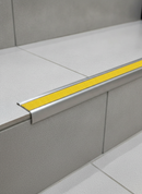 Retro-fit stainless steel anti-slip stair nosing R11 Yellow RAL 1021 tread TREP-GK on tiled stairs